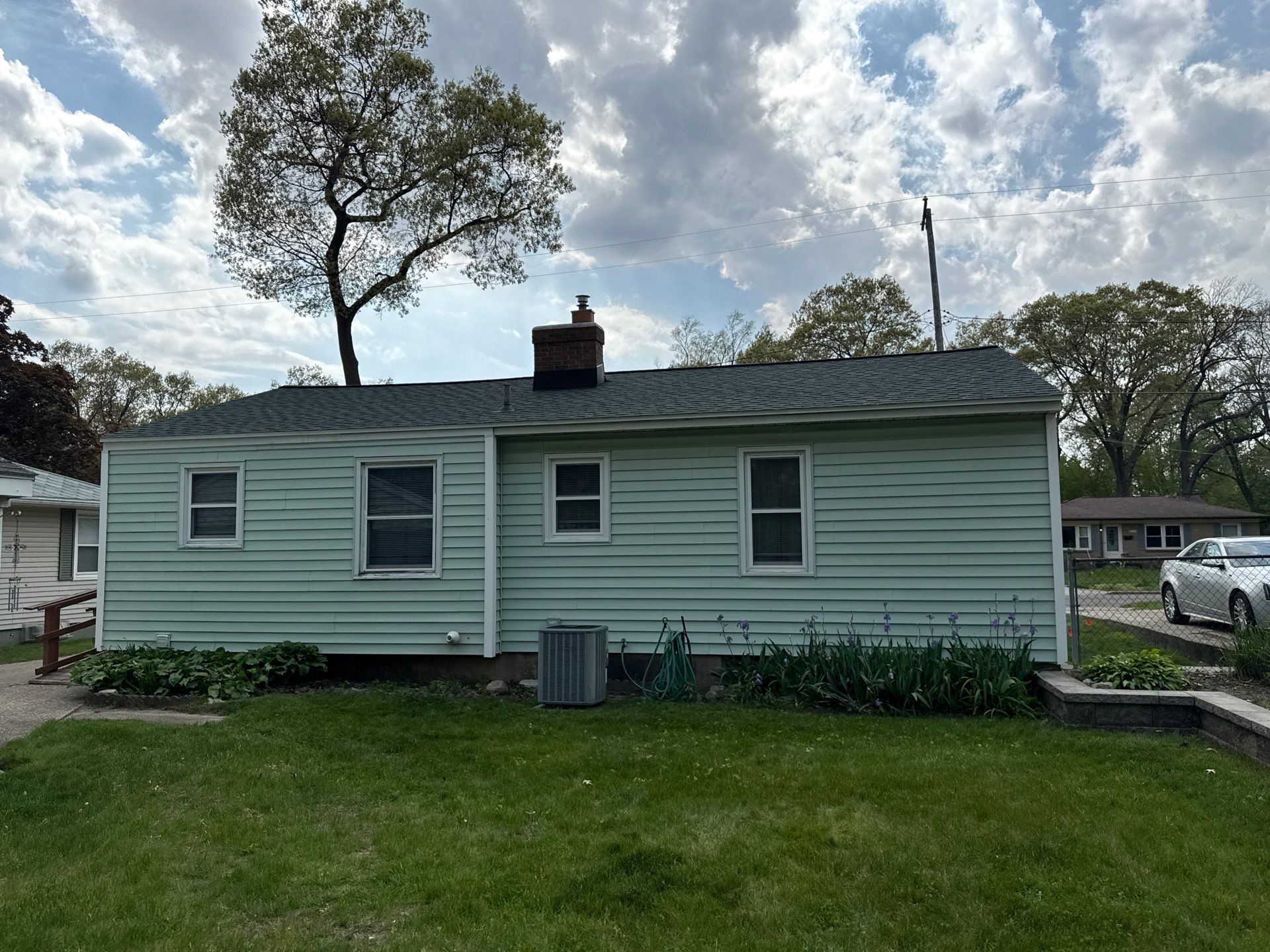 Rear view of a Wyoming, MI home with a new shingle roof and rebuilt chimney flashing
