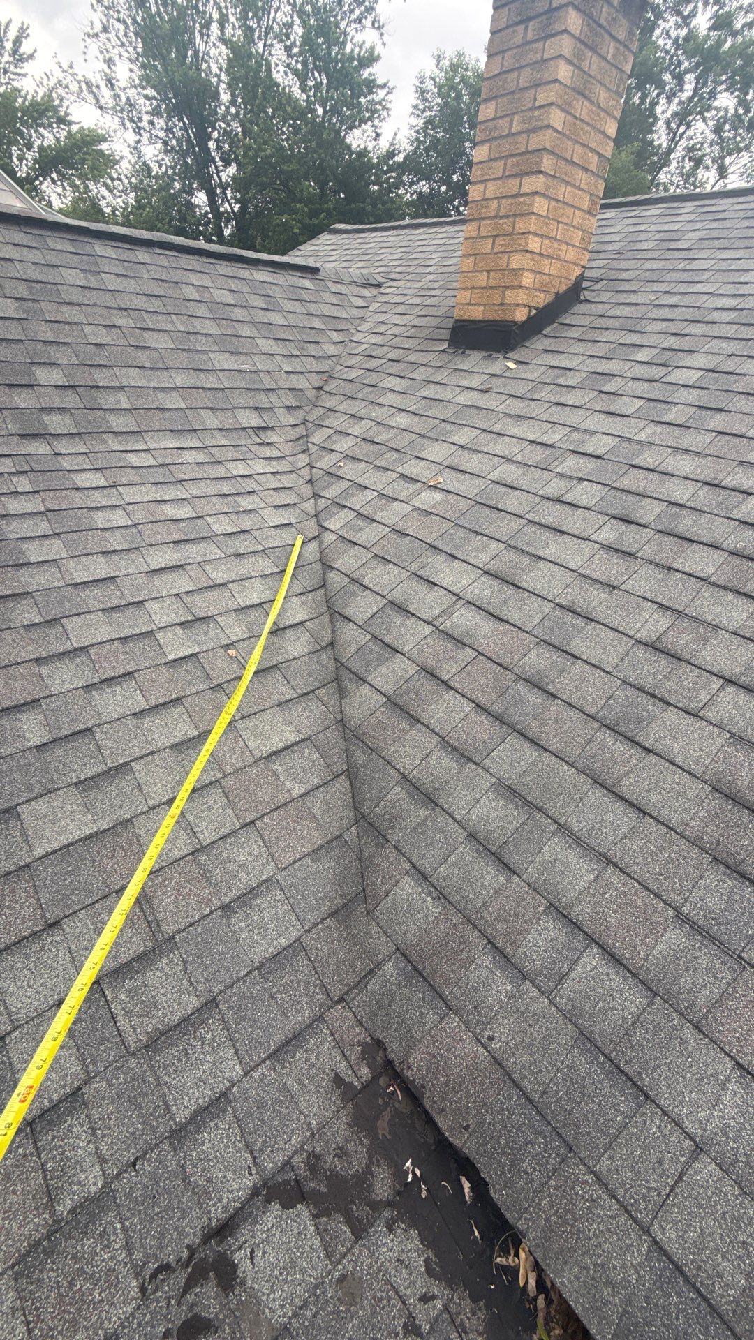 Roof valley and chimney inspection with tape measure on a Wyoming, MI home on Sharon Ave