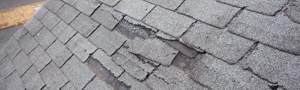 Close-up of hail-damaged asphalt shingles on a Grand Rapids roof