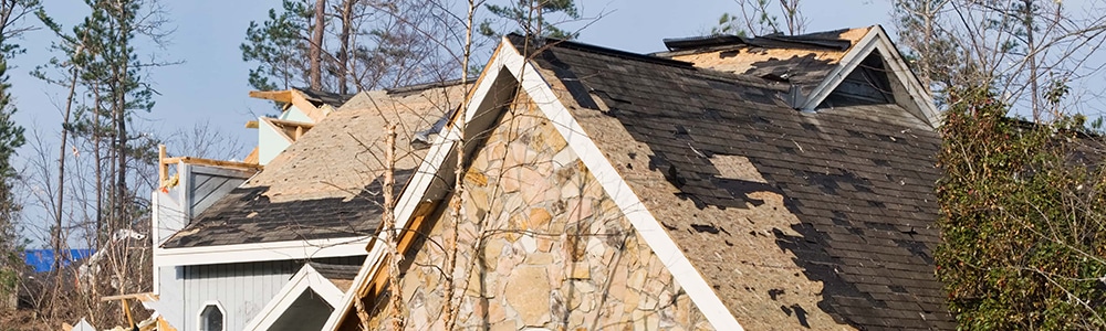 Wind-damaged roof on a West Michigan home after a severe storm