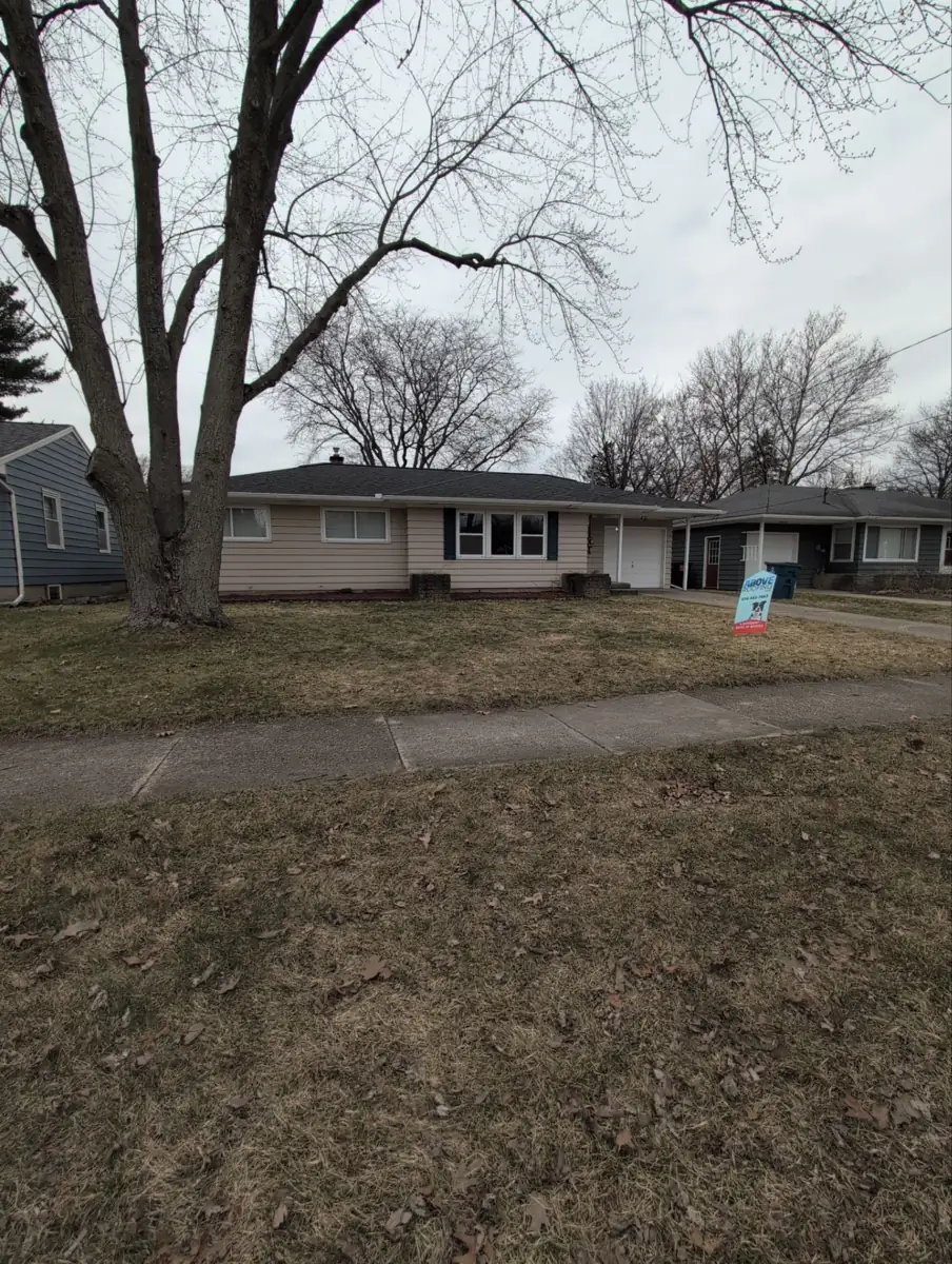 Ranch home in Kentwood, MI with a new roof and an Above Roofing yard sign
