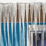 Icicles that have formed on the side of a house, causing ice dams