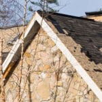 House with missing shingles after weather damage
